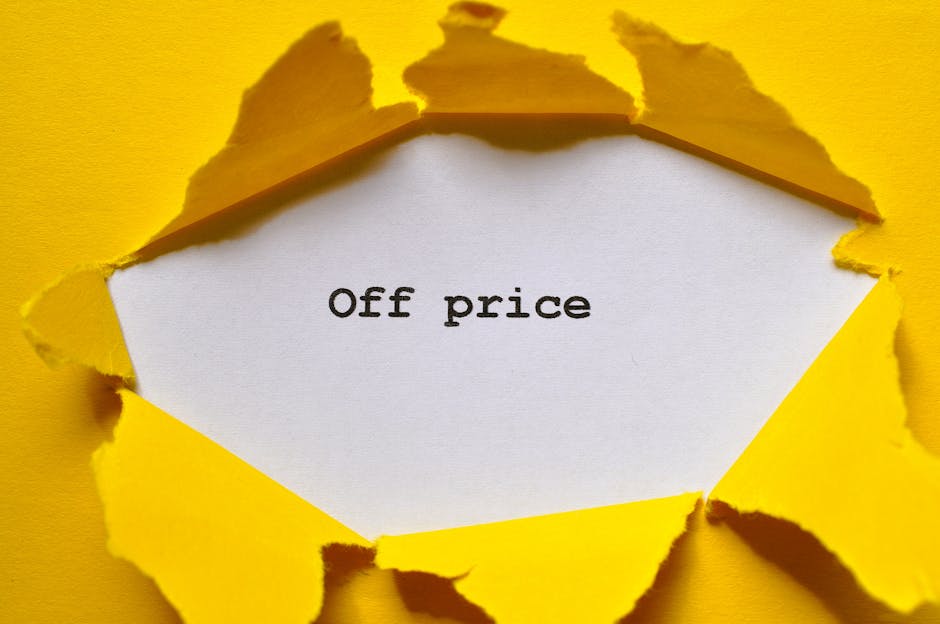 A close-up of a yellow paper torn open to reveal a white sheet underneath with the words 'Off price' printed in black. The torn edges of the yellow paper are irregular and slightly curled. The background is a plain yellow surface matching the torn paper, creating a contrast that highlights the message. This image is associated with pricing and discount themes relevant to house removals and relocation services, subtly supporting the topic of transparent moving costs as discussed on the webpage for Preston removals by Man with Van Preston.