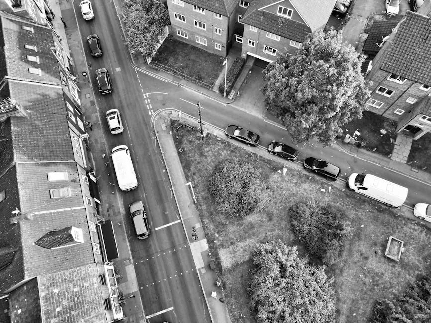A street scene in Preston featuring a row of multi-storey Victorian-style buildings with brick facades and large windows, some with decorative cornices, lining the sidewalk. The street is paved, with a pedestrian crossing and traffic bollards visible in the foreground. Two double-decker buses are parked adjacent to the curb, alongside a few cars. Several pedestrians, dressed in casual clothing, are walking on the pavement near storefronts, including a shop with a large sign reading 'Bella Italia'. The area appears busy, with activity typical of a town centre. This setting provides the context for home relocation and furniture transport services, aligning with the themes of moving logistics supported by Man with Van Preston, especially in urban environments where careful loading and unloading are essential for efficient removals.